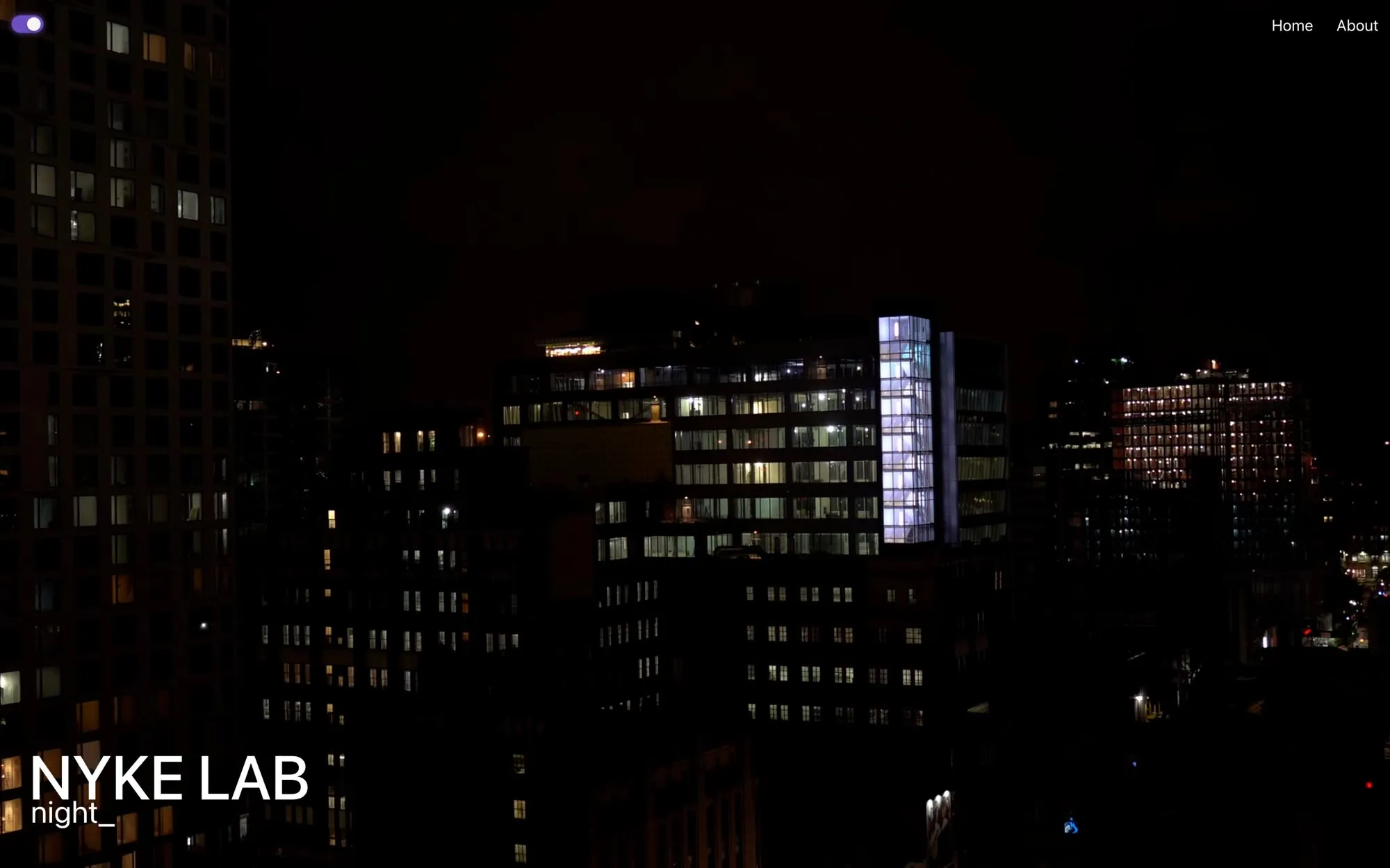 A dark city skyline at night with lit windows. NYKE LAB and the word night sit at the bottom left, and a small toggle is switched on at the top left.